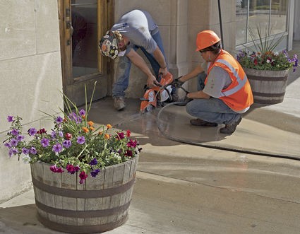 construction company workers cutting sidewalk